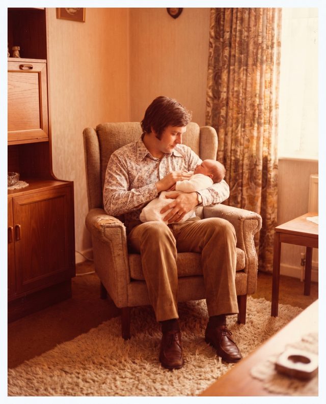 A 1971 photograph of a young father cradling his newborn baby, coming to life