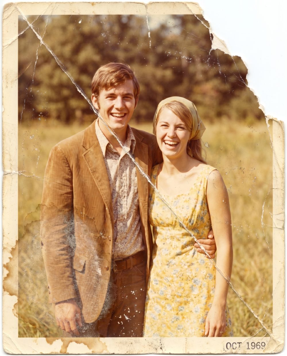 The same 1969 photograph before restoration — faded, creased, water-stained and torn